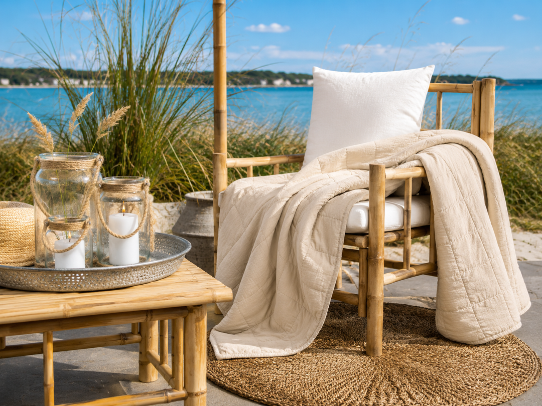 Cremefarbener Quilt dekorativ auf Bambusstuhl im sommerlichen Boho Landhausstil