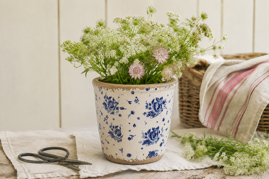 Clayre & Eef Blumentopf mit blauem Rosenmuster und Wildblumen auf nostalgischer Fensterbank im Landhausstil