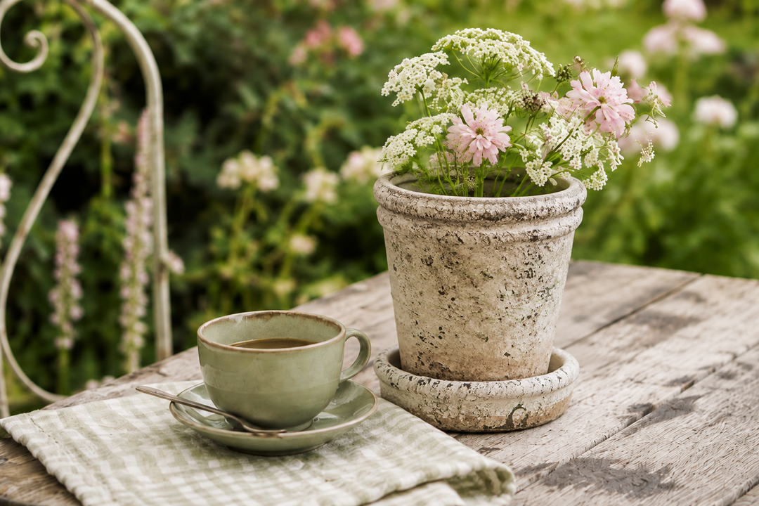 Clayre & Eef Blumentopf im Vintage Landhausstil mit weißen und rosa Sommerblumen auf rustikalem Gartentisch
