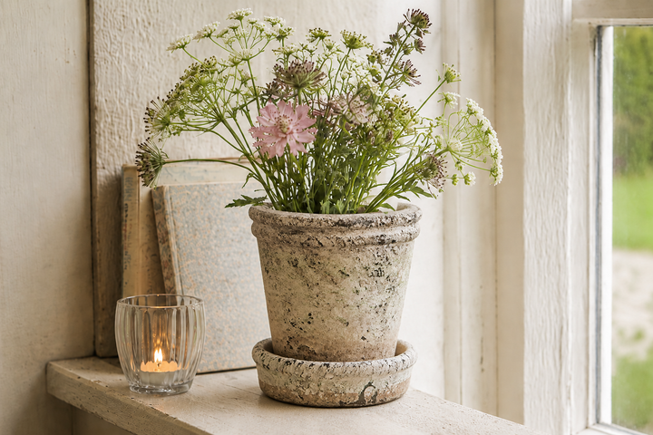 Vintage Blumentopf von Clayre & Eef mit Sommerblumen neben Windlicht und Büchern auf heller Fensterbank im Shabby Chic Stil