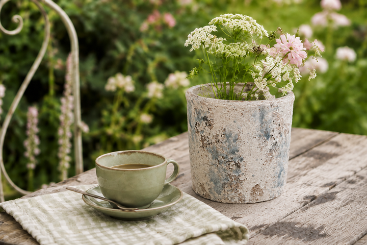 Clayre & Eef Blumentopf in Weiß-Blau auf rustikalem Gartentisch im romantischen Landhausstil dekoriert