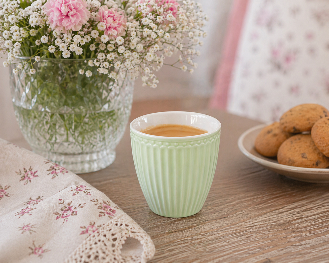 GreenGate Mini Latte Cup Alice hellgrün in Nutzung mit Espresso auf Holztisch im skandinavischen Landhausstil mit Blumen