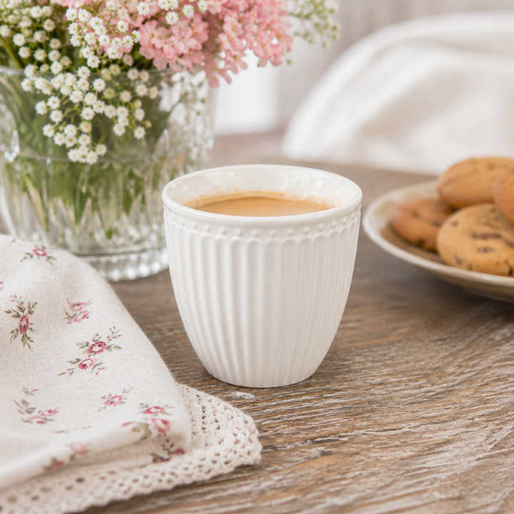 GreenGate Mini Latte Cup Alice weiß in Nutzung mit Espresso auf Holztisch im skandinavischen Landhausstil mit Blumen und Gebäck