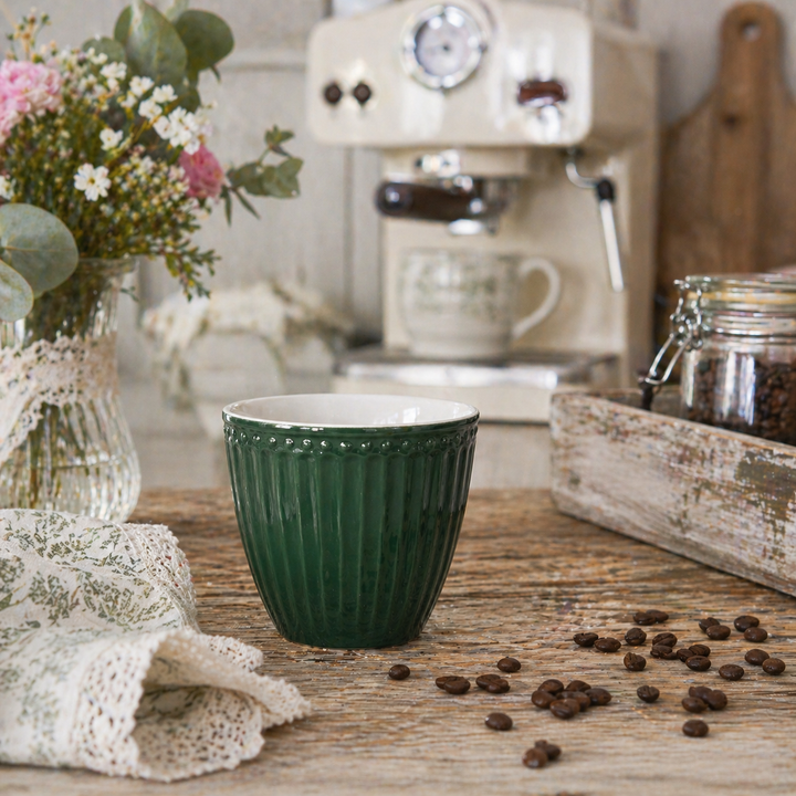 GreenGate Alice Tasse olivgrün auf Holztisch mit Kaffeemaschine und Kaffeebohnen im Landhausstil