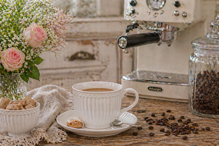 GreenGate Tasse mit Untertasse Alice weiß auf rustikalem Holztisch mit Kaffeemaschine und Kaffeebohnen im Landhausstil