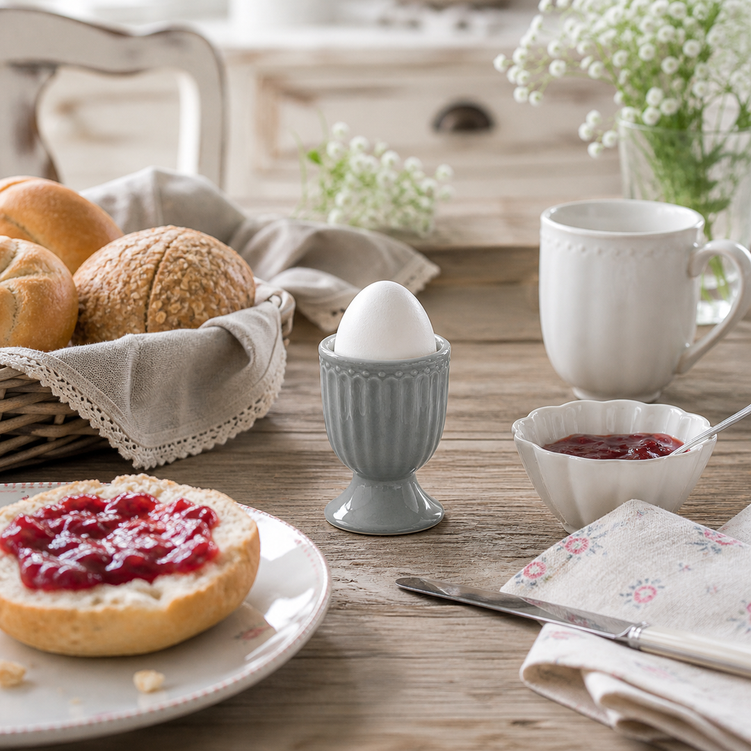 GreenGate Eierbecher Alice Steingrau in Frühstücksszene mit Brötchen und Marmelade auf Holztisch im Landhausstil