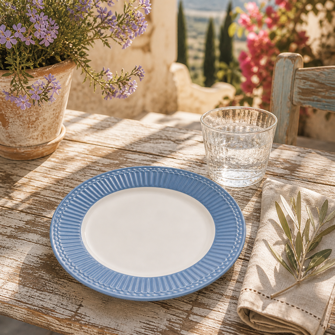 GreenGate Frühstücksteller Alice Hellblau 23 cm auf sommerlicher Terrasse im mediterranen Landhausstil mit Sonne Blumen und rustikalem Tisch