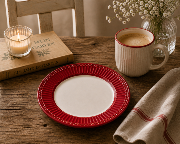 GreenGate Frühstücksteller Alice Rot 23 cm in gemütlicher Kaffee Szene mit Tasse warmem Licht und rustikalem Vintage Stil