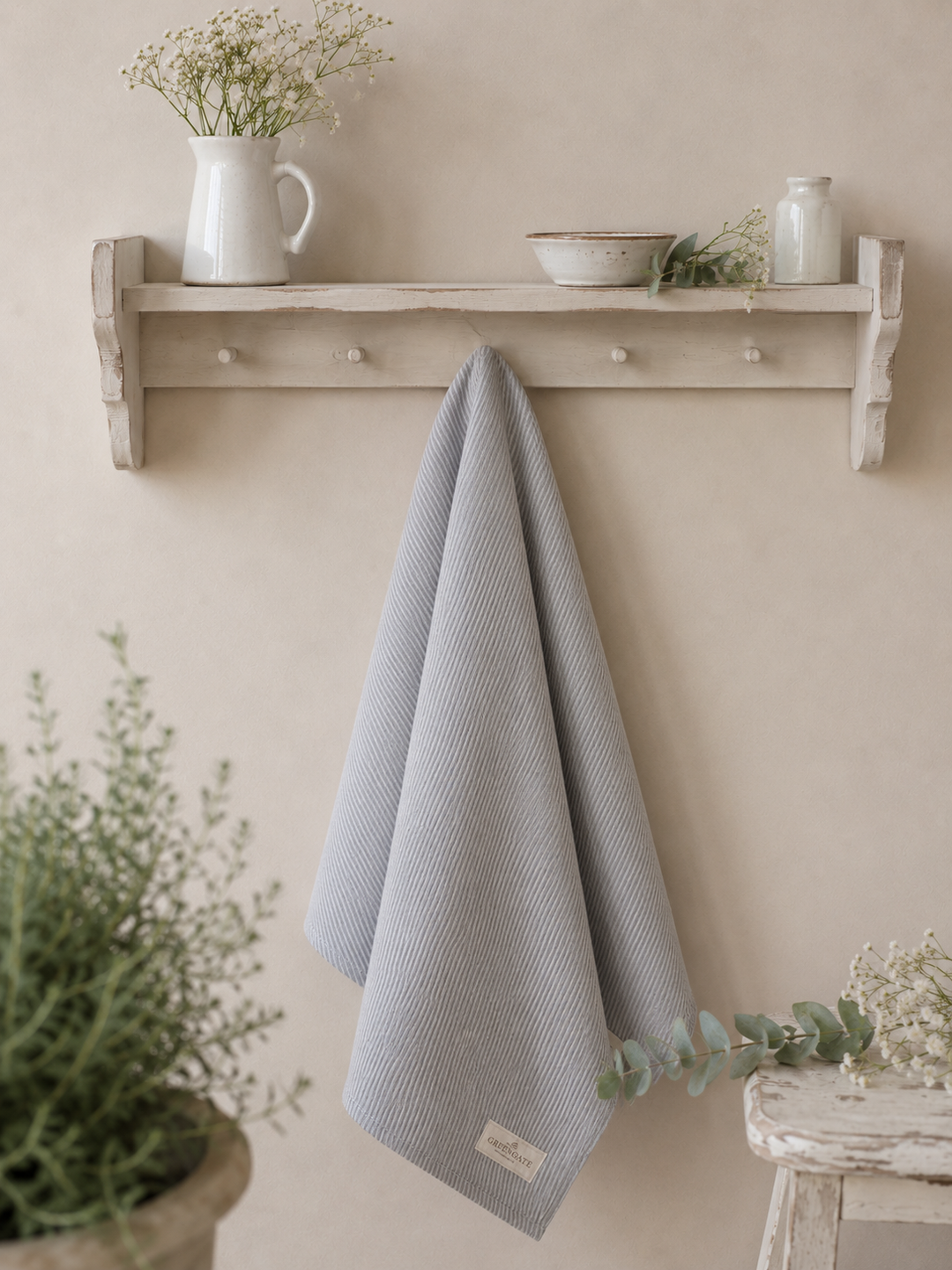 GreenGate Geschirrtuch Alicia Hellgrau locker hängend an weißem Landhausregal mit Keramik und Blumen