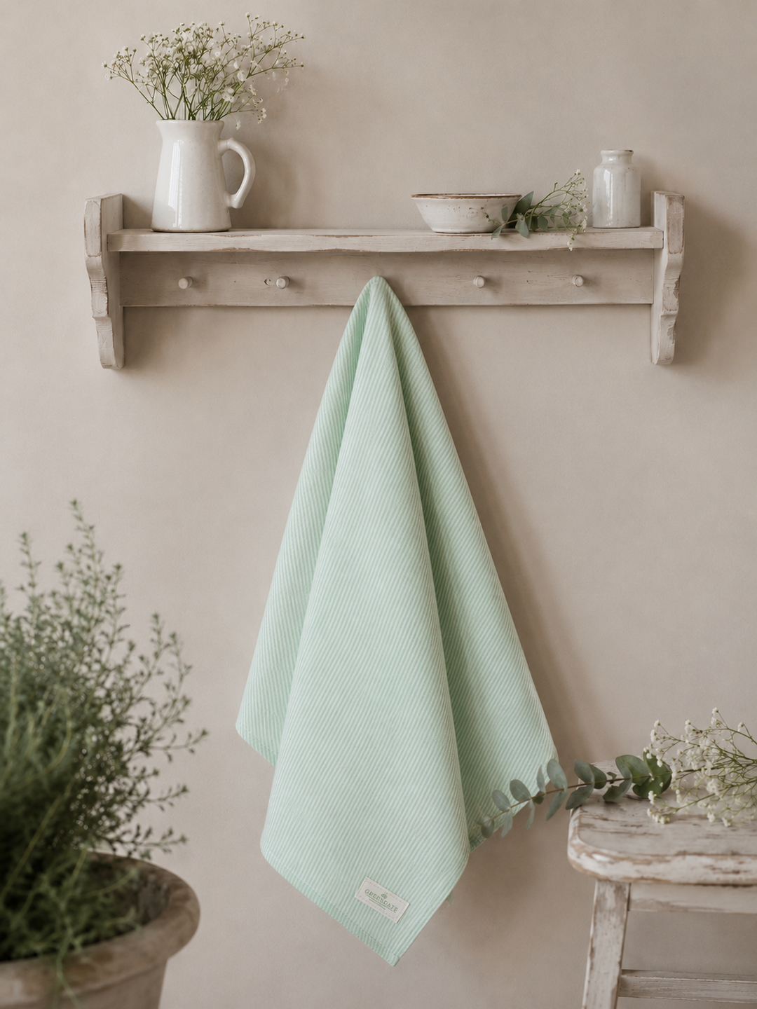 GreenGate Geschirrtuch Alicia Hellgrün locker hängend an weißem Landhausregal mit Keramik und Blumen