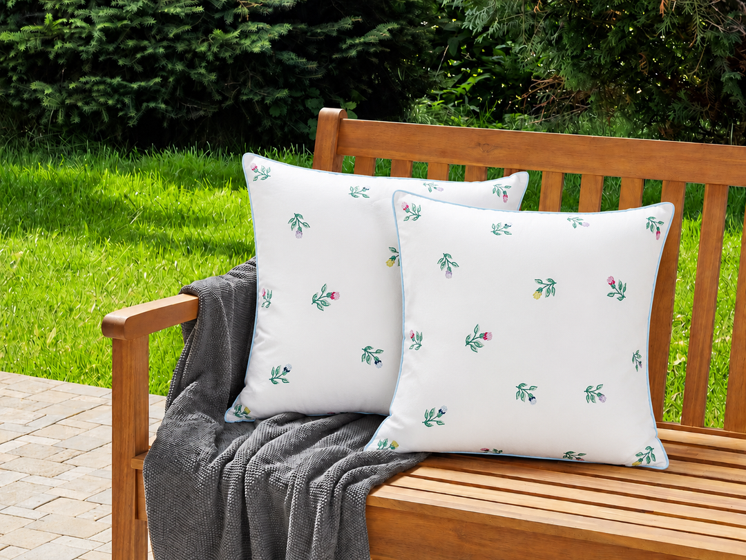GreenGate Kissenbezug Gaya Weiß mit Stickerei 40x40 auf Holzbank im sommerlichen Landhausgarten mit natürlicher Outdoor Dekoration