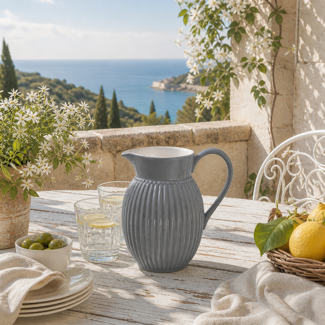 GreenGate Krug Alice Steingrau 1,5 L auf sommerlicher Terrasse mit Blumen, Sonne und mediterraner Atmosphäre