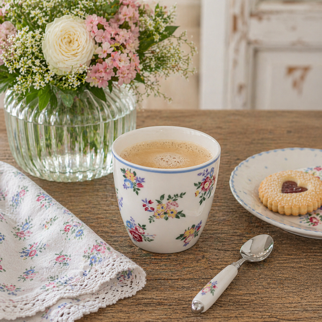 GreenGate Latte Becher Elena Petit weiß geblümt in Nutzung mit Kaffee auf Holztisch im skandinavischen Landhausstil