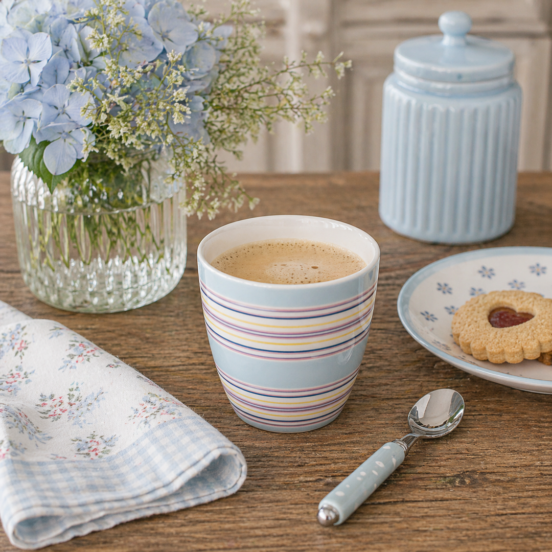GreenGate Latte Becher Nera hellblau mit Streifen in Nutzung mit Kaffee auf Holztisch im skandinavischen Landhausstil