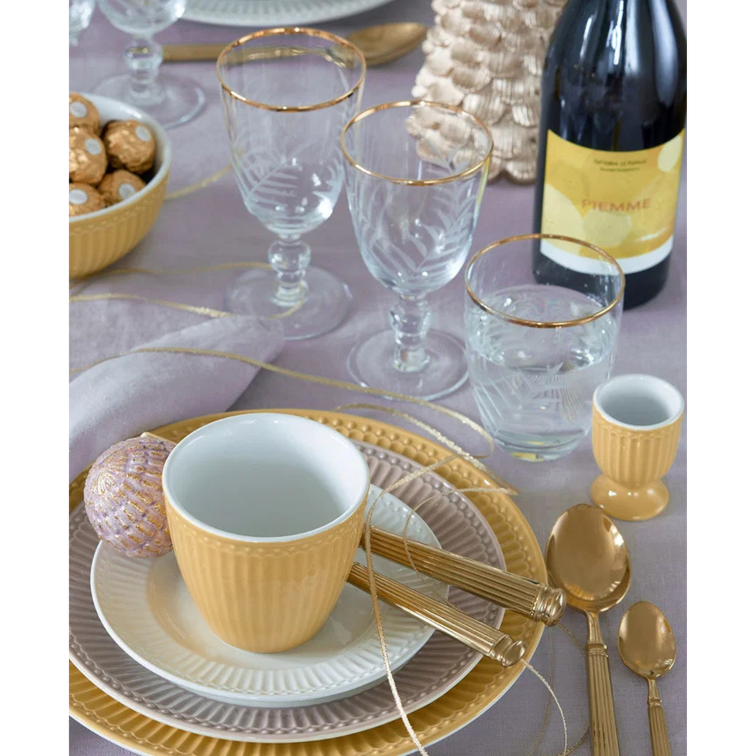 GreenGate Latte Cup Alice Senfgelb in festlicher Tischdekoration mit goldfarbenem Besteck und skandinavischem Porzellan