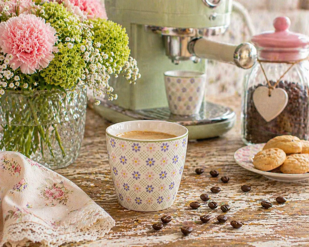GreenGate Latte Cup Sybille weiß floral auf rustikalem Holztisch mit Kaffeemaschine und Kaffeebohnen im Shabby Chic Landhausstil
