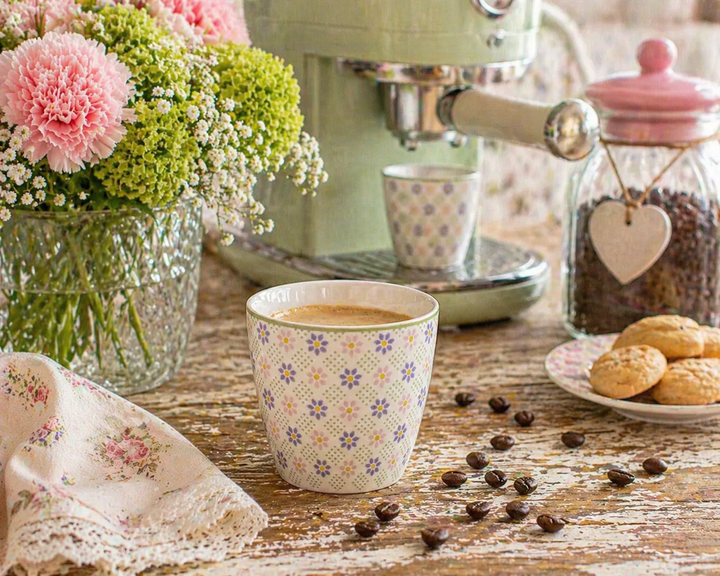 GreenGate Latte Cup Sybille weiß floral auf rustikalem Holztisch mit Kaffeemaschine und Kaffeebohnen im Shabby Chic Landhausstil