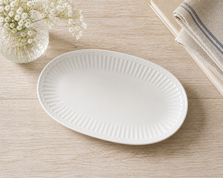 GreenGate Servierteller Alice weiß oval auf hellem Holztisch im Landhausstil, minimal und clean