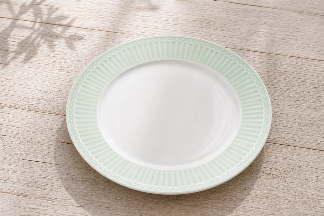 GreenGate Speiseteller Alice Hellgrün 27 cm auf hellem Landhaus Tisch von schräg oben fotografiert minimalistisch und ruhig inszeniert