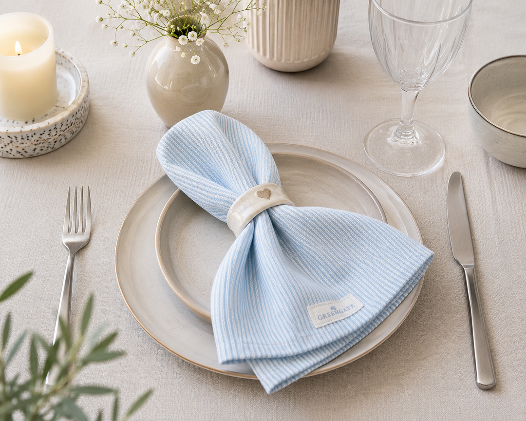 GreenGate Stoffserviette Alicia hellblau auf cremefarbenem Teller mit Serviettenring im skandinavischen Landhausstil