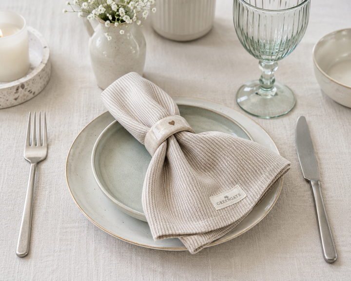 GreenGate Stoffserviette Alicia Sand auf gedecktem Tisch im skandinavischen Landhausstil mit heller Keramik und Leinentischdecke