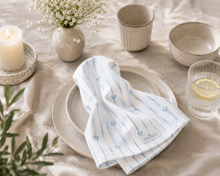 GreenGate Stoffserviette mit blauem Schleifenmuster auf hellem Keramikteller im minimalistischen skandinavischen Landhausstil