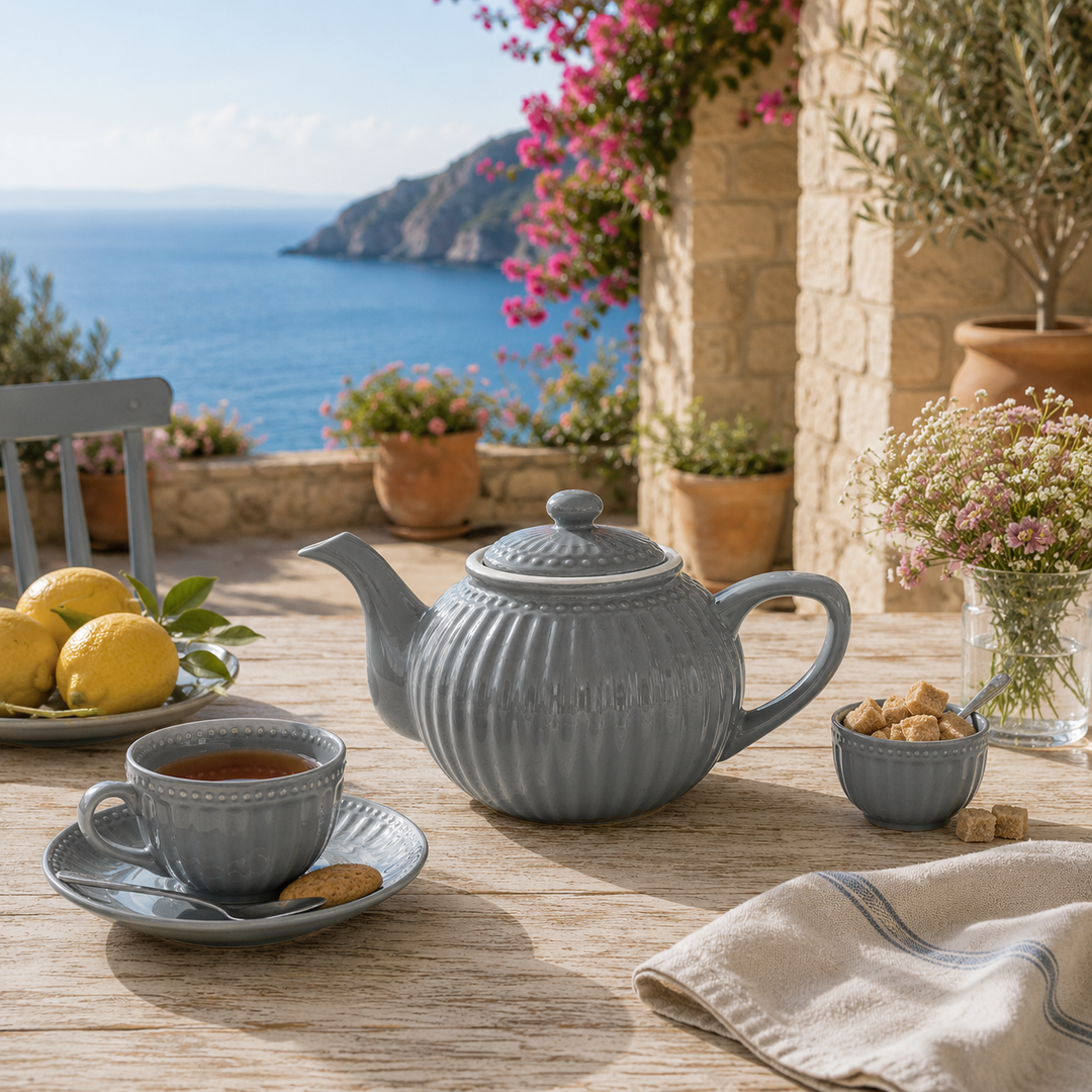 GreenGate Teekanne Alice Steingrau 1 L auf sommerlicher Terrasse im mediterranen Landhausstil mit Meerblick