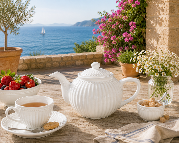 GreenGate Teekanne Alice Weiß 1 L auf sommerlicher Terrasse im mediterranen Landhausstil mit Meerblick