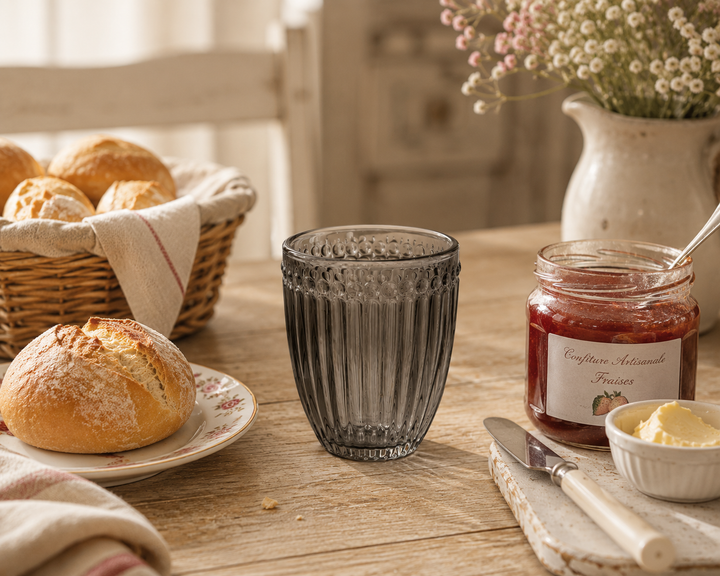 GreenGate Wasserglas Alice Grau auf rustikalem Frühstückstisch mit Brötchen und Marmelade im warmen Landhausstil