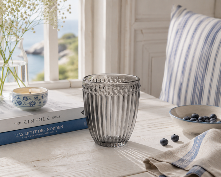 GreenGate Wasserglas Alice Grau auf hellem Landhaus Holztisch mit weichem Tageslicht im skandinavischen Stil