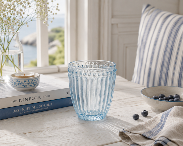 GreenGate Wasserglas Alice Hellblau auf hellem Landhaus Tisch mit weichem Licht im skandinavischen Stil