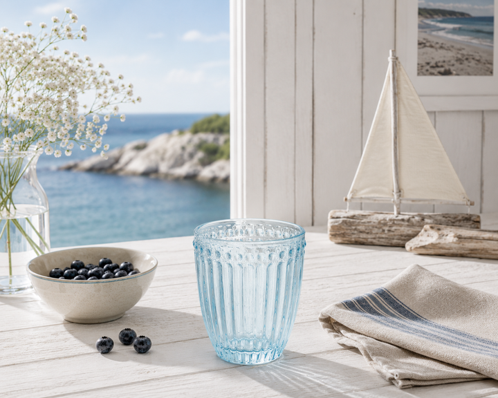 GreenGate Wasserglas Alice Hellblau in heller skandinavischer Küstenküche mit maritimer Dekoration und Meerblick