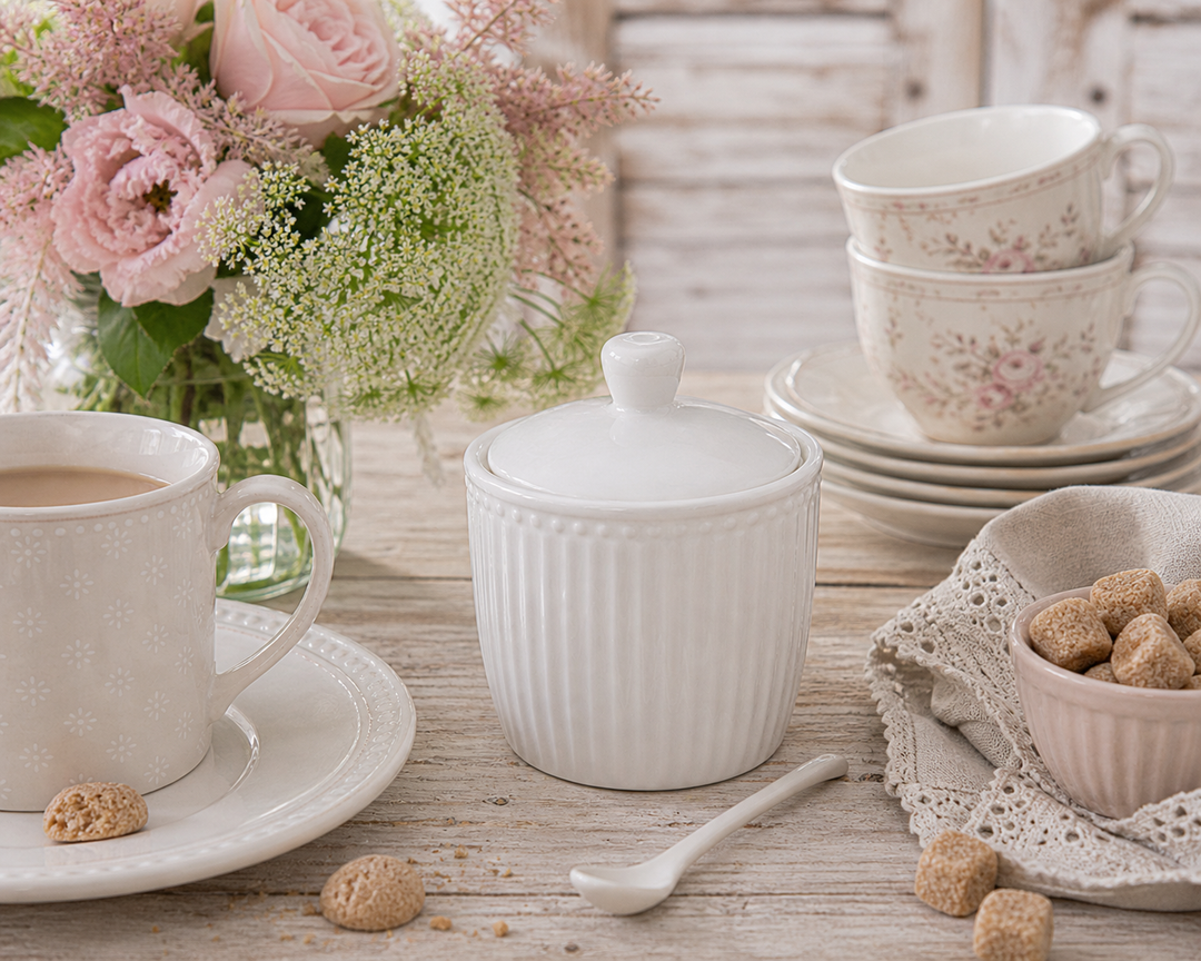 GreenGate Zuckerdose Alice Weiß auf gedecktem Frühstückstisch im skandinavischen Landhausstil mit Tasse, Blumen und Zuckerwürfeln