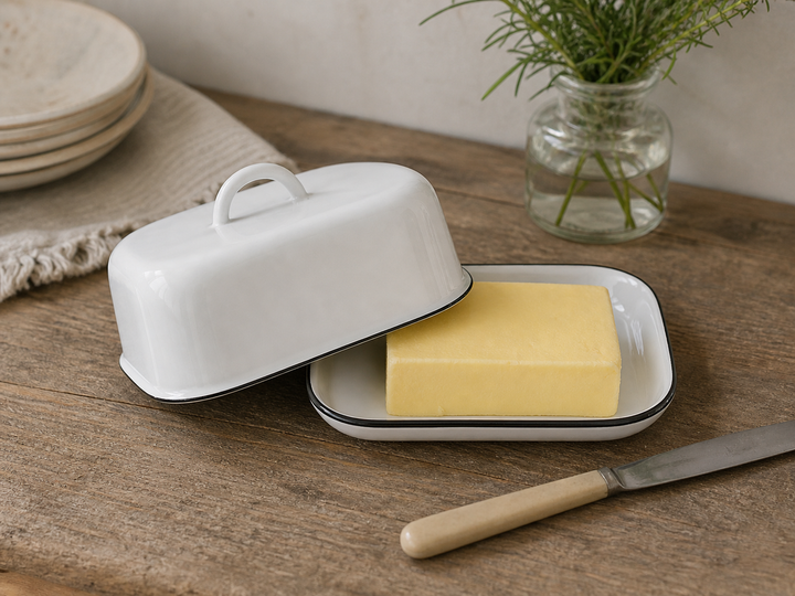 Ib Laursen Butterdose Emaille weiß mit schwarzem Rand mit Butter auf Holztisch im Landhausstil