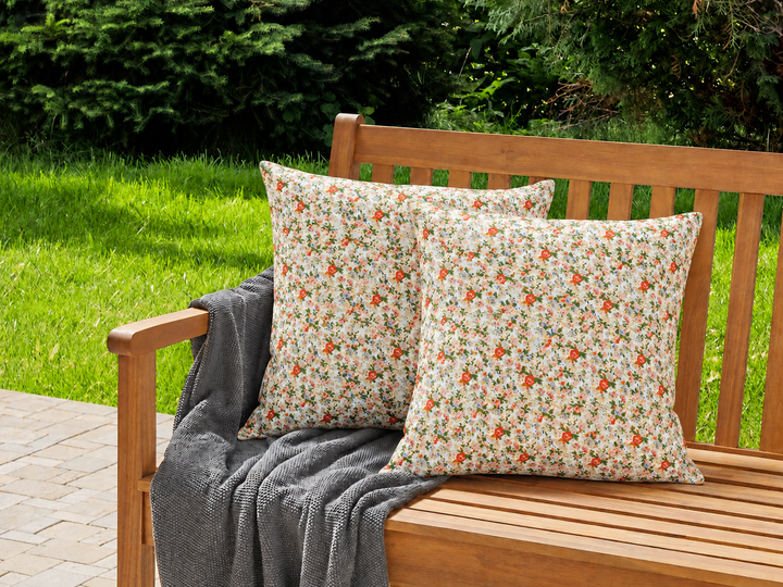 Ib Laursen Kissenbezug geblümt Orange Rosa Creme 60x60 auf Gartenbank im sommerlichen Landhausstil mit natürlicher Terrasse