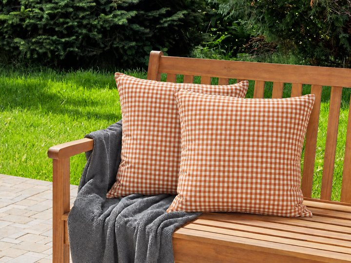 IB Laursen Kissenbezug orange weiß kariert auf Holzbank im Garten im skandinavischen Landhausstil