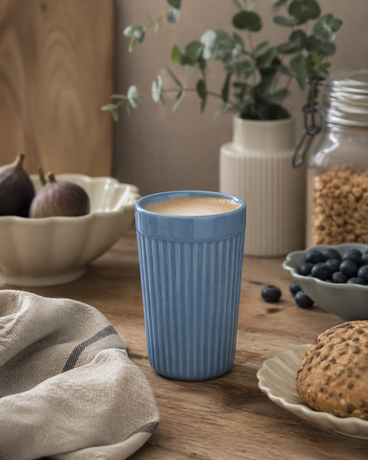 IB Laursen Mynte Café Latte Becher Blue Bell in Nutzung als Kaffeebecher in skandinavischer Küchenszene mit Frühstück und natürlicher Dekoration