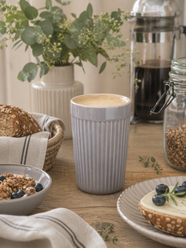 IB Laursen Mynte Café Latte Becher French Grey in Nutzung als Kaffeebecher in skandinavischer Küchenszene mit Frühstück und natürlicher Dekoration