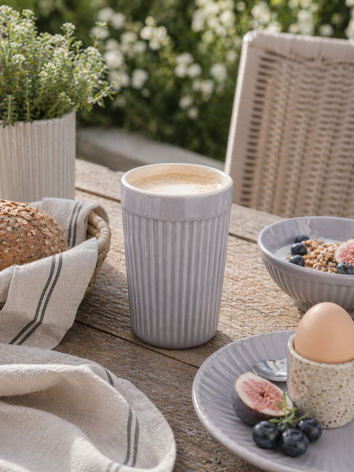 IB Laursen Mynte Café Latte Becher French Grey in Nutzung auf Terrasse beim Frühstück mit Kaffee, Schale und skandinavischer Outdoor Tischdekoration