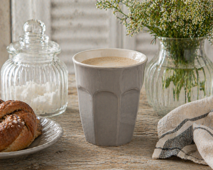 IB Laursen Mynte® Café Latte Becher French Grey mit Kaffee in Nutzung auf gedecktem Tisch im skandinavischen Landhausstil