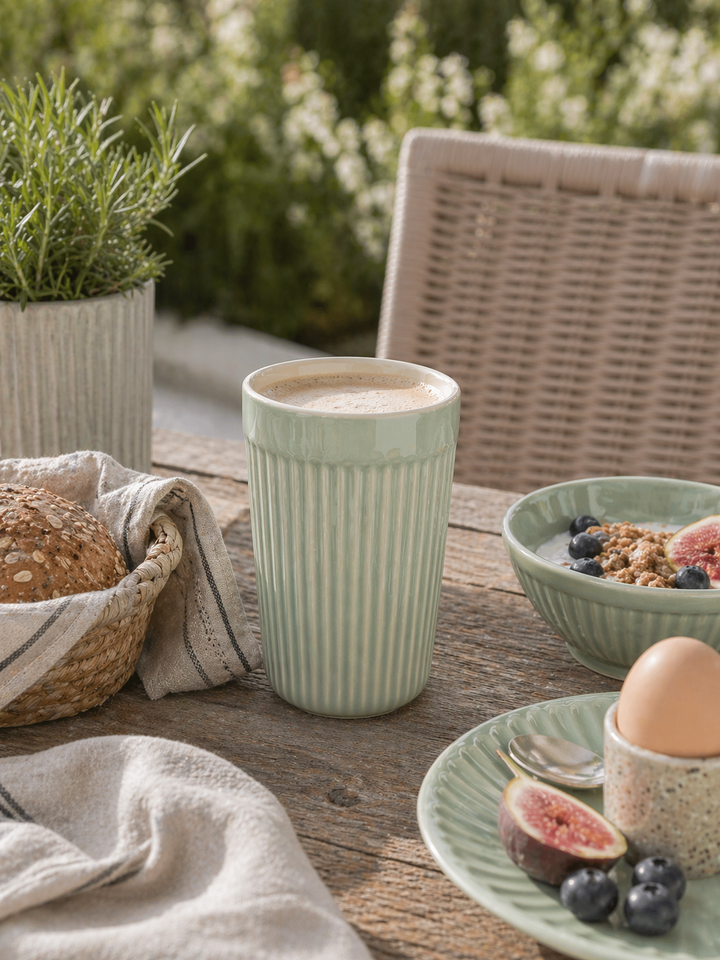 IB Laursen Mynte Café Latte Becher Green Tea in Nutzung auf Terrasse beim Frühstück mit Kaffee, Schale und skandinavischer Outdoor Tischdekoration