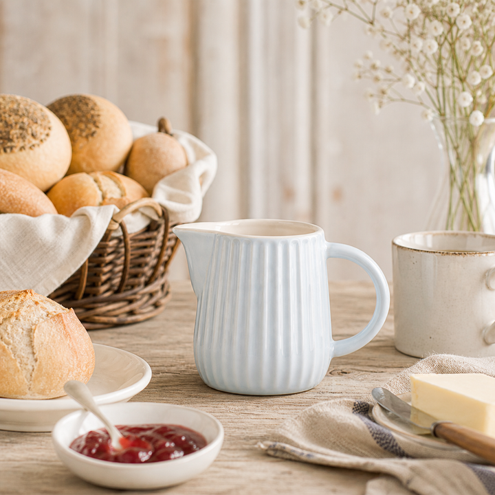 Ib Laursen Mynte Milch- und Sahnekännchen Stillwater 200 ml im Landhaus Frühstück Setting mit Brötchen Marmelade und Holz Tisch