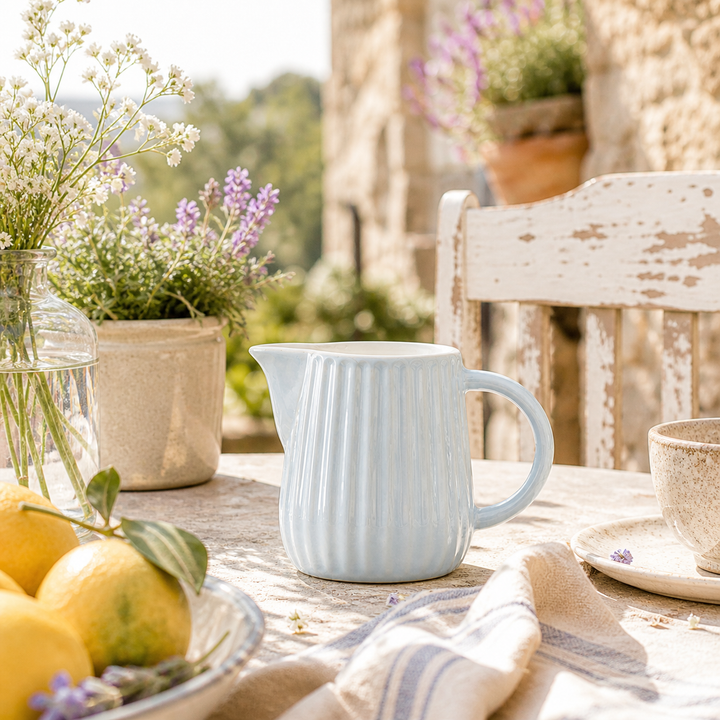 Ib Laursen Mynte Milch- und Sahnekännchen Stillwater 200 ml auf sommerlicher Terrasse im mediterranen Landhausstil mit Sonne und Blumen