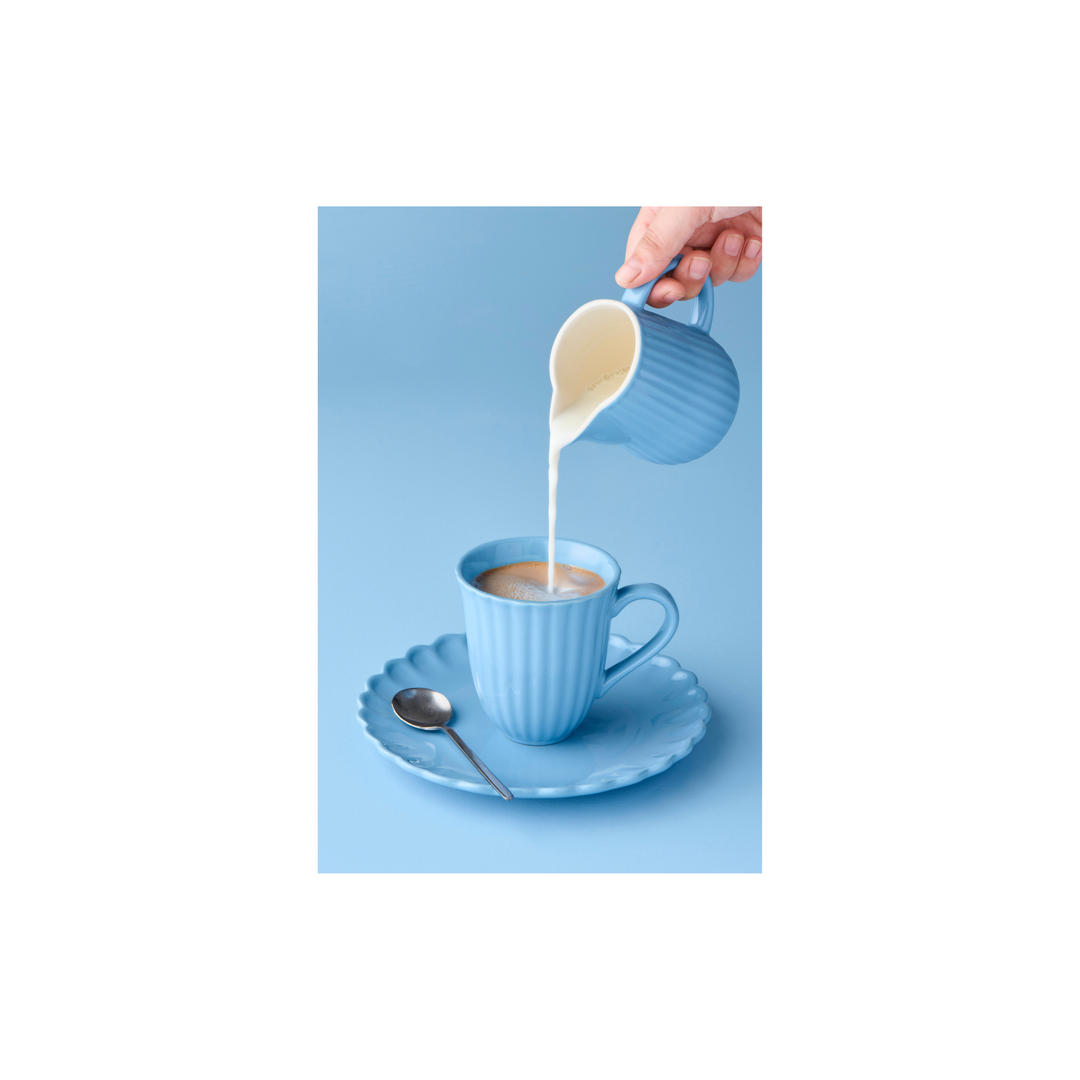 IB Laursen Mynte Tasse Blue Bell beim Eingießen von Milch in Kaffee im skandinavischen Stil