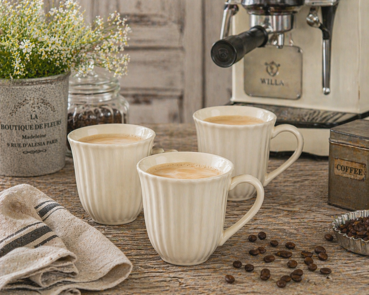 IB Laursen Mynte Tasse Butter Cream auf urigem Holztisch mit Kaffeemaschine und Kaffeebohnen im Shabby Chic Stil