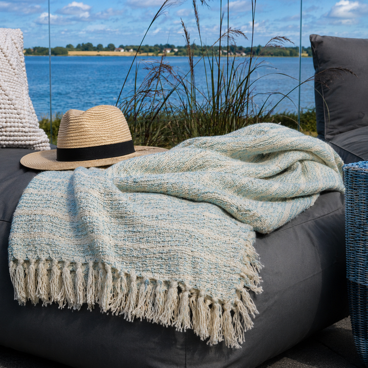 Mintfarbenes Chic Antique Plaid auf gemütlicher Terrasse am Wasser im skandinavischen Stil