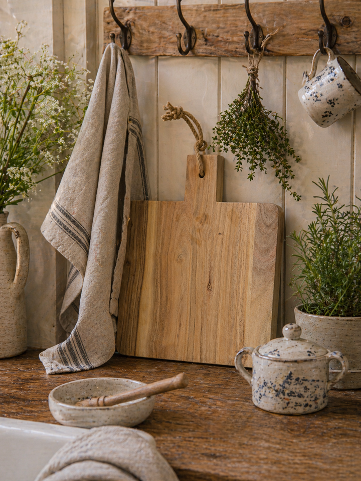 Ib Laursen Schneidebrett quadratisch aus Holz mit Juteseil in Landhausküche aufgehängt mit Leinenhandtuch, Keramik und Kräutern im Shabby Chic Stil