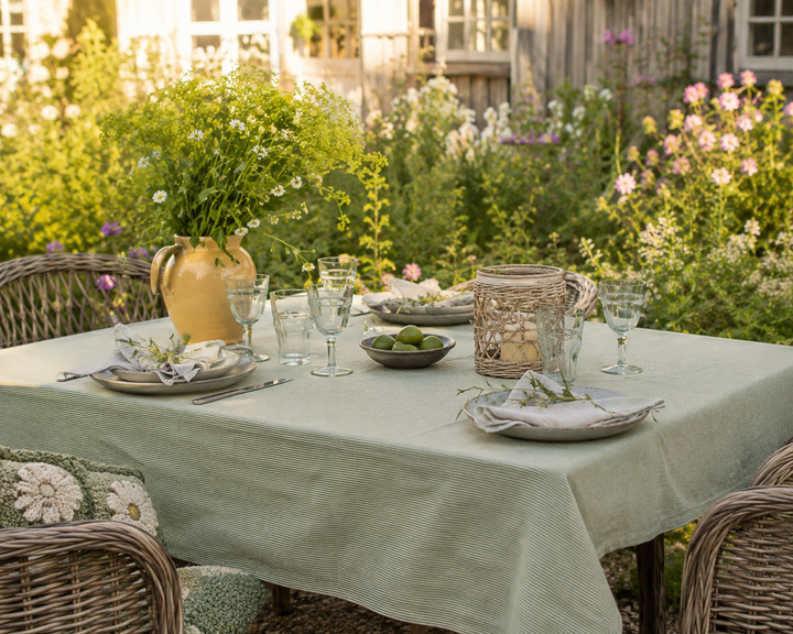 Ib Laursen Tischdecke Emil Grün Natur mit feinen Streifen auf sommerlichem Gartentisch im skandinavischen Landhausstil